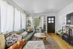 Living area with light wood-style flooring and recessed lighting