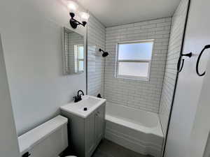 Bathroom featuring toilet, tile patterned flooring, bathtub / shower combination, and vanity