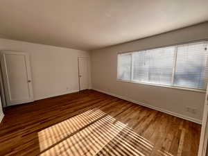 Unfurnished room featuring wood finished floors and baseboards
