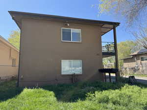 View of home's exterior with fence, a balcony, and concrete block siding