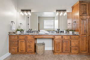 Full bath featuring double vanity and baseboards