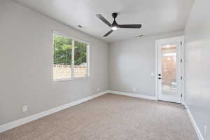 Empty room with carpet flooring, baseboards, and a ceiling fan