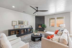 Living area with wood finished floors, ceiling fan, a fireplace, recessed lighting, and baseboards