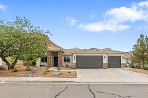 View of front of house featuring a garage, stucco siding, driveway, stone siding, and a tile roof