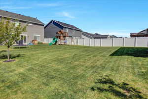 View of yard featuring a trampoline and a playground