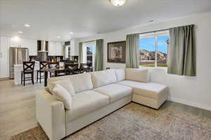 Living room with baseboards, light wood-style floors, and recessed lighting