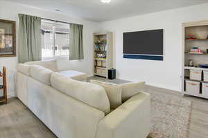 Living room with light wood-style flooring and baseboards