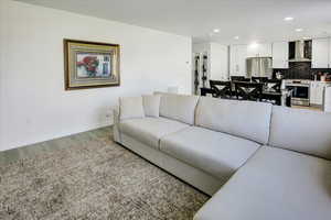 Living area with light wood-style flooring, recessed lighting, and baseboards