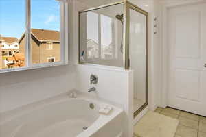 Bathroom with a shower stall, tile patterned floors, and a garden tub