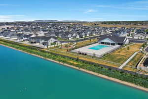 Aerial view of residential area featuring a pool area and a nearby body of water