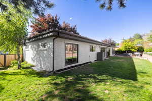 Rear view of house with brick siding, central AC unit, and a patio area