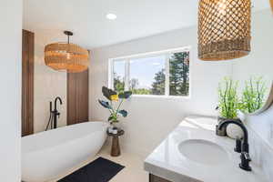 Bathroom with a soaking tub, double vanity, baseboards, recessed lighting, and tile patterned flooring