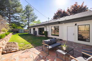 Back of property with a patio area, a storage shed, a yard, and central air condition unit