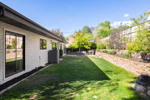 View of yard with central air condition unit and a patio