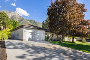 View of front of house featuring a garage, a mountain view, driveway, and brick siding