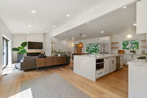 Kitchen featuring open shelves, white cabinetry, open floor plan, light wood-style floors, and recessed lighting