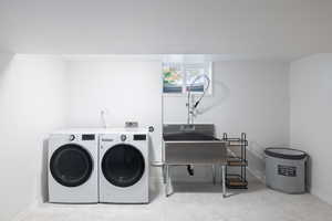 Laundry room featuring washing machine and dryer and baseboards