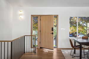 Foyer entrance featuring wood finished floors, healthy amount of natural light, and baseboards