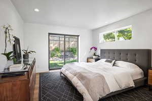 Bedroom featuring multiple windows, dark wood finished floors, recessed lighting, access to exterior, and baseboards