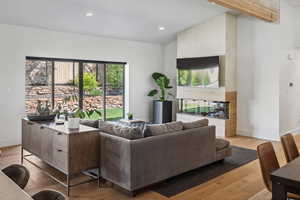 Living room with lofted ceiling, wood finished floors, baseboards, and recessed lighting