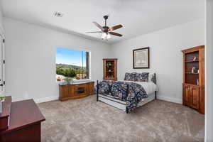Bedroom with light carpet and a ceiling fan