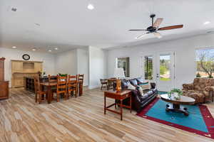 Living room with recessed lighting, a ceiling fan, baseboards, and light wood-style floors