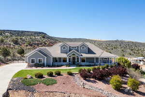 View of front of home with a mountain view, covered porch, and a front lawn