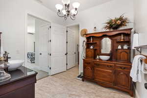 Full bathroom featuring two vanities and a chandelier