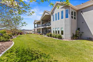 View of side of home featuring stucco siding, stairs, and a lawn