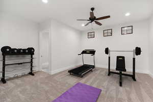 Workout room featuring light colored carpet, a ceiling fan, and recessed lighting