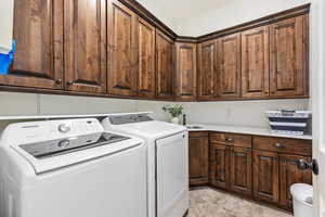 Laundry area featuring washing machine and dryer and cabinet space