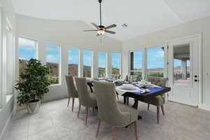 Sunroom / solarium with tile patterned floors and high vaulted ceiling
