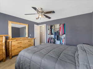 Carpeted bedroom featuring ceiling fan and a closet