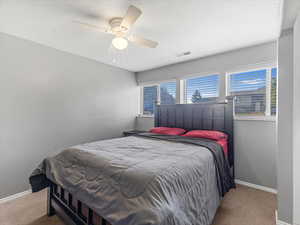 Bedroom with carpet flooring, baseboards, and ceiling fan