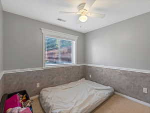Carpeted bedroom with ceiling fan and baseboards