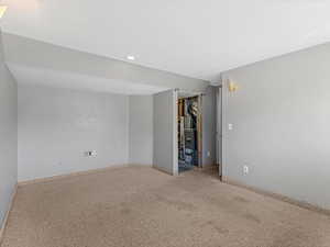Carpeted empty room featuring baseboards and recessed lighting