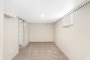 Finished basement with baseboards and light carpet