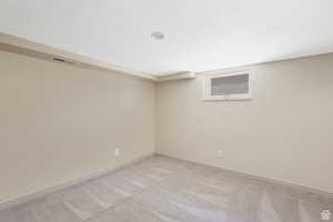 Empty room featuring visible vents, carpet, and baseboards