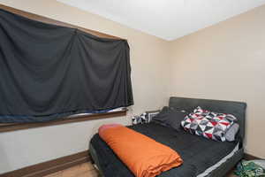 Bedroom with baseboards and wood finished floors