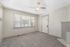 Empty room featuring a ceiling fan, baseboards, visible vents, and carpet