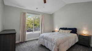 Bedroom with dark carpet, lofted ceiling, baseboards, and a ceiling fan