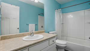 Bathroom with shower / tub combo, toilet, and vanity