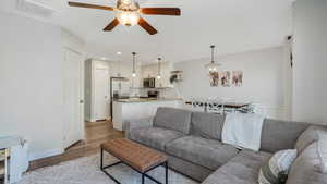 Living room featuring ceiling fan, light wood-style flooring, and recessed lighting