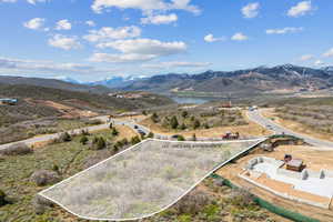 Aerial view of property and surrounding area featuring property boundaries highlighted and a water and mountain view