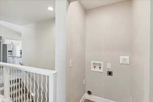 Washroom with electric dryer hookup, hookup for a washing machine, baseboards, and recessed lighting