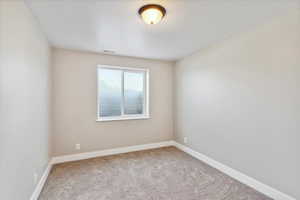Carpeted empty room with baseboards