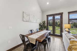 Dining space with french doors, plenty of natural light, and high vaulted ceiling