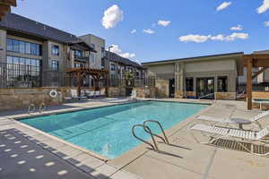 Community pool featuring fence, a pergola, a patio area, and a hot tub