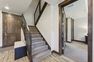 Stairway with baseboards and wood finished floors