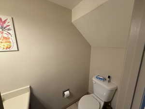 Bathroom with lofted ceiling and toilet